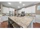 Kitchen island featuring granite countertops, seating, and modern sink and faucet, complemented by white cabinets at 145 Basket Grass Ln, Summerville, SC 29486