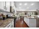 Open kitchen layout features granite counters, white cabinets, stainless steel appliances, and an island with seating at 145 Basket Grass Ln, Summerville, SC 29486