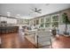 Bright living room features hardwood floors, modern furnishings, and an open layout to the kitchen and outdoor views at 145 Basket Grass Ln, Summerville, SC 29486