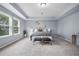 Bright main bedroom featuring a tray ceiling, carpet, natural light from the windows, and neutral tones at 145 Basket Grass Ln, Summerville, SC 29486