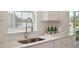 Close-up of a kitchen sink with white countertops and cabinets by the window at 153 Threaded Fern St, Summerville, SC 29485