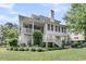 Expansive backyard with lush landscaping, a covered porch, and stairs leading down to the manicured lawn at 1531 Capel St, Mount Pleasant, SC 29466