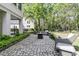 Backyard stone patio featuring wicker furniture, a fire pit, and manicured landscaping at 1531 Capel St, Mount Pleasant, SC 29466