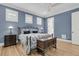 This bedroom boasts an iron bed frame, hardwood floors, a blue accent wall, and plantation shutters at 1531 Capel St, Mount Pleasant, SC 29466
