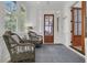 Cozy sunroom with wicker chairs, natural light, and a glass paneled wooden door at 1531 Capel St, Mount Pleasant, SC 29466