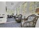 Bright sunroom featuring wicker furniture, large windows, and serene views of the surrounding greenery at 1531 Capel St, Mount Pleasant, SC 29466