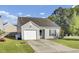 Inviting single-story home featuring a spacious driveway, green lawn, and classic architectural details at 157 Tyger St, Summerville, SC 29485