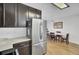Kitchen area with stainless steel refrigerator, dark cabinetry, and dining area with table and chairs at 157 Tyger St, Summerville, SC 29485