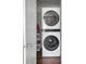 Efficient laundry closet with stacked washer and dryer units and storage shelves at 157 Tyger St, Summerville, SC 29485