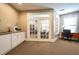 A bright office space with french doors leading to the library, and a desk near a window at 1615 Chatelain Way, Mount Pleasant, SC 29464