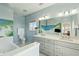 Stylish bathroom featuring double sink vanity, a tub, and themed wall art at 1676 E Ashley Ave, Folly Beach, SC 29439