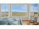 Cozy bedroom with ample natural light from bay windows overlooking serene marsh landscape, with hardwood floors at 1676 E Ashley Ave, Folly Beach, SC 29439
