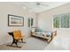 A cozy bedroom with a twin bed, quaint wooden desk chair and large windows with natural light at 1676 E Ashley Ave, Folly Beach, SC 29439