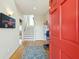 Welcoming entryway with a bright red door, hardwood floors, and staircase at 1676 E Ashley Ave, Folly Beach, SC 29439