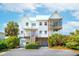 Beautiful home exterior featuring a spacious driveway and lush landscaping at 1676 E Ashley Ave, Folly Beach, SC 29439