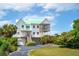 Charming raised beach house with a screened porch, garage and lush landscaping at 1676 E Ashley Ave, Folly Beach, SC 29439