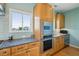 Well-equipped kitchen with custom wood cabinets, granite countertops, stainless steel oven and views from the window at 1676 E Ashley Ave, Folly Beach, SC 29439