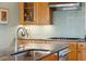 Close-up of a kitchen island with granite counters, stainless faucet and wood cabinets in a well-lit, stylish home at 1676 E Ashley Ave, Folly Beach, SC 29439