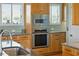 This kitchen features built-in appliances, wood cabinets and granite countertops beneath natural lighting at 1676 E Ashley Ave, Folly Beach, SC 29439