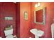 Unique powder room with vibrant walls, pedestal sink, and decorative accents at 1676 E Ashley Ave, Folly Beach, SC 29439