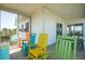 Relaxing screened porch furnished with vibrant chairs offers comfortable outdoor living and views of the surroundings at 1676 E Ashley Ave, Folly Beach, SC 29439