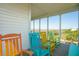 Inviting screened porch with colorful chairs offers a relaxing space to enjoy views of the landscape at 1676 E Ashley Ave, Folly Beach, SC 29439