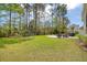Large backyard featuring a playground, fire pit, and sitting area surrounded by lush greenery at 1755 Bolden Dr, Mount Pleasant, SC 29466