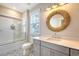 Bright bathroom featuring a decorative round mirror, quartz countertops, grey cabinets, and a tub at 1755 Bolden Dr, Mount Pleasant, SC 29466