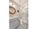 Bathroom with a round mirror, grey cabinets, patterned tile floor, and tub with glass doors at 1755 Bolden Dr, Mount Pleasant, SC 29466