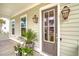 Inviting front porch with potted plants, decorative lanterns, and a stylish front door at 1755 Bolden Dr, Mount Pleasant, SC 29466