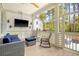 Inviting screened-in porch featuring a comfortable seating area, outdoor television and backyard views at 1755 Bolden Dr, Mount Pleasant, SC 29466
