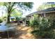 Residential backyard featuring a trampoline, car, shed, and lush greenery at 20 Anderson Ave, Charleston, SC 29412
