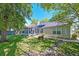 Rear exterior view showcasing a screened porch, a well-maintained lawn, and a fire pit at 208 Evesham Dr, Summerville, SC 29485