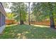 Green backyard featuring a wood fence and mature trees, creating a private outdoor space at 208 Evesham Dr, Summerville, SC 29485