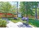 Private backyard oasis with lush greenery, a fire pit, grilling area, and storage shed at 208 Evesham Dr, Summerville, SC 29485