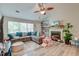 Cozy living room with a large sectional sofa, ceiling fan, fireplace, and a large window for natural light at 208 Evesham Dr, Summerville, SC 29485