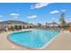 Large community pool with lounge chairs, umbrellas, and clubhouse under a partly cloudy sky at 218 Wexford Ct, Summerville, SC 29483