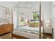 Bright bedroom with a four-poster bed, two windows, hardwood floors, and soft, neutral decor at 22 Sheppard St, Charleston, SC 29403