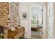 Hallway view showcasing brick wall with vintage-style window pane, leading into bedroom with natural light at 22 Sheppard St, Charleston, SC 29403