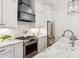 Bright kitchen with white cabinets, marble countertops, stainless steel appliances, range hood, and modern lighting at 22 Sheppard St, Charleston, SC 29403