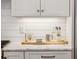 Marble countertops, white cabinets and backsplash with modern stainless steel accessories at 22 Sheppard St, Charleston, SC 29403