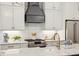 Bright kitchen with white cabinets, marble countertops, stainless steel appliances, and modern range hood at 22 Sheppard St, Charleston, SC 29403