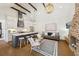 Open-concept living room with exposed beams, gourmet kitchen, brick fireplace, and elegant chandelier at 22 Sheppard St, Charleston, SC 29403