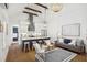 Open-concept living space featuring modern kitchen, exposed beams, and brick fireplace with mantel at 22 Sheppard St, Charleston, SC 29403