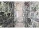 Close-up of a luxurious green marble tiled shower with modern fixtures at 22 Sheppard St, Charleston, SC 29403