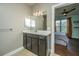 Bathroom vanity featuring a dark cabinet, a granite countertop, modern fixtures and bedroom view at 2244 Ashley Crossing Drive Dr # 621, Charleston, SC 29414