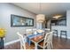Bright dining room featuring a wood table, white chairs, stylish light fixture, and adjacent kitchen view at 2244 Ashley Crossing Drive Dr # 621, Charleston, SC 29414