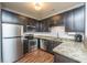 Compact kitchen with stainless steel appliances, granite countertops, and dark cabinets at 2244 Ashley Crossing Drive Dr # 621, Charleston, SC 29414