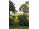 Serene backyard view with lush greenery and a glimpse of the ocean in the distance at 2407 Atlantic Ave, Sullivans Island, SC 29482
