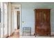 Bedroom hallway with wooden floors, patterned wallpaper, an antique wardrobe, and French doors at 2407 Atlantic Ave, Sullivans Island, SC 29482